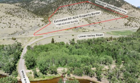 Aerial view of a hillside with a red outline marking an 80-acre property boundary and labeled roads seen below the line, with a river at the bottom.